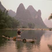 A cormorant fisherman prepares his bamboo raft, Li River, Yangshou, China